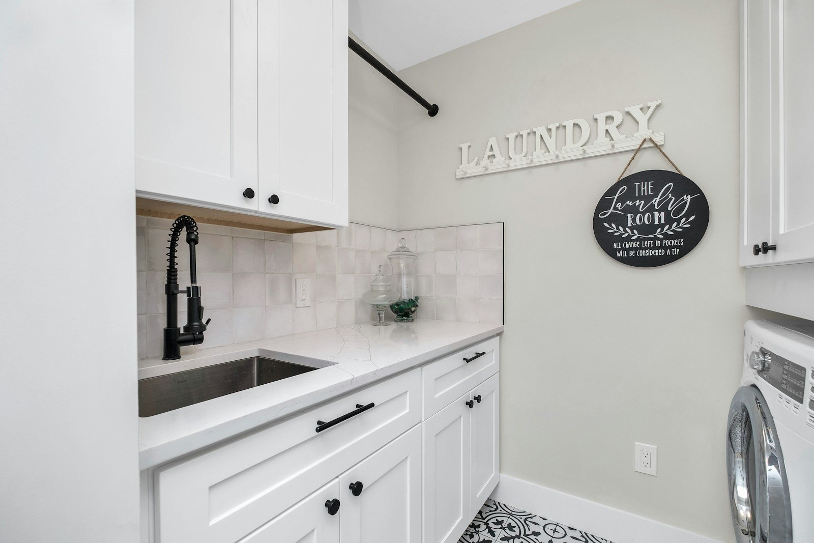Laundry room with white cabinets, sink and folding counter